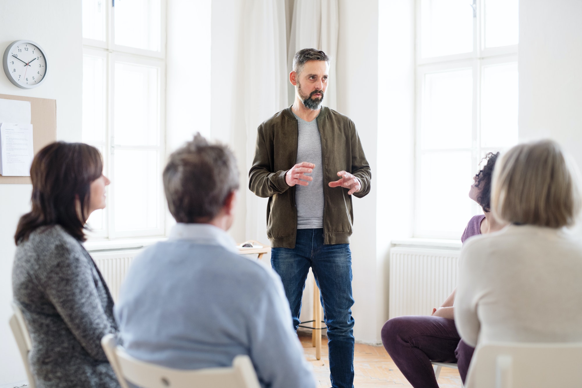 a man talking to other people during group therapy